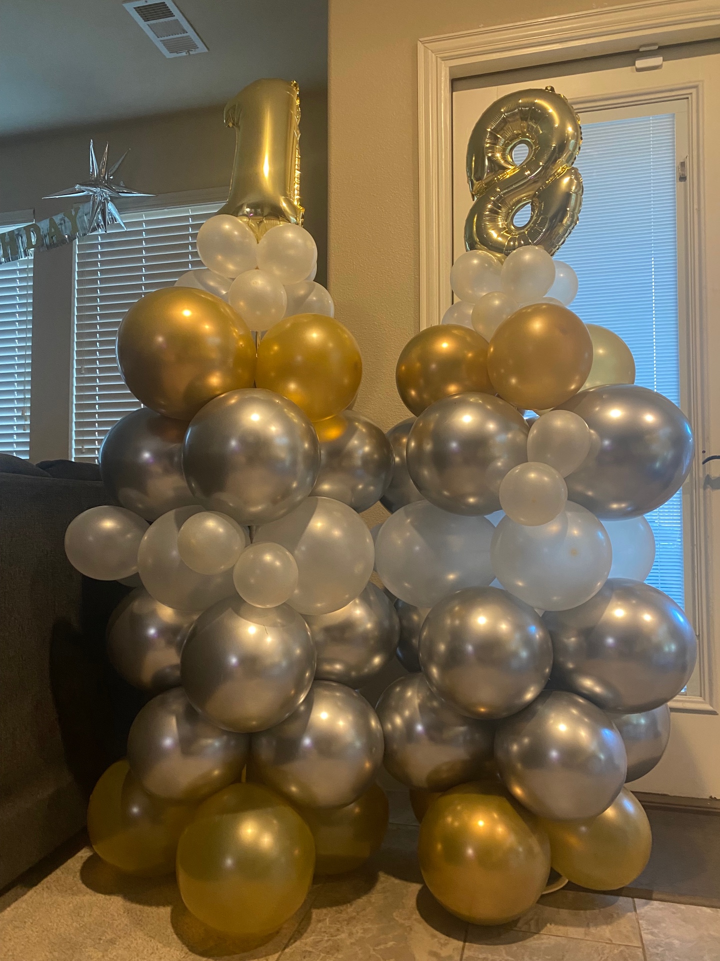 Pair of gold, silver, and white balloon columns with number 18 foil toppers for a birthday