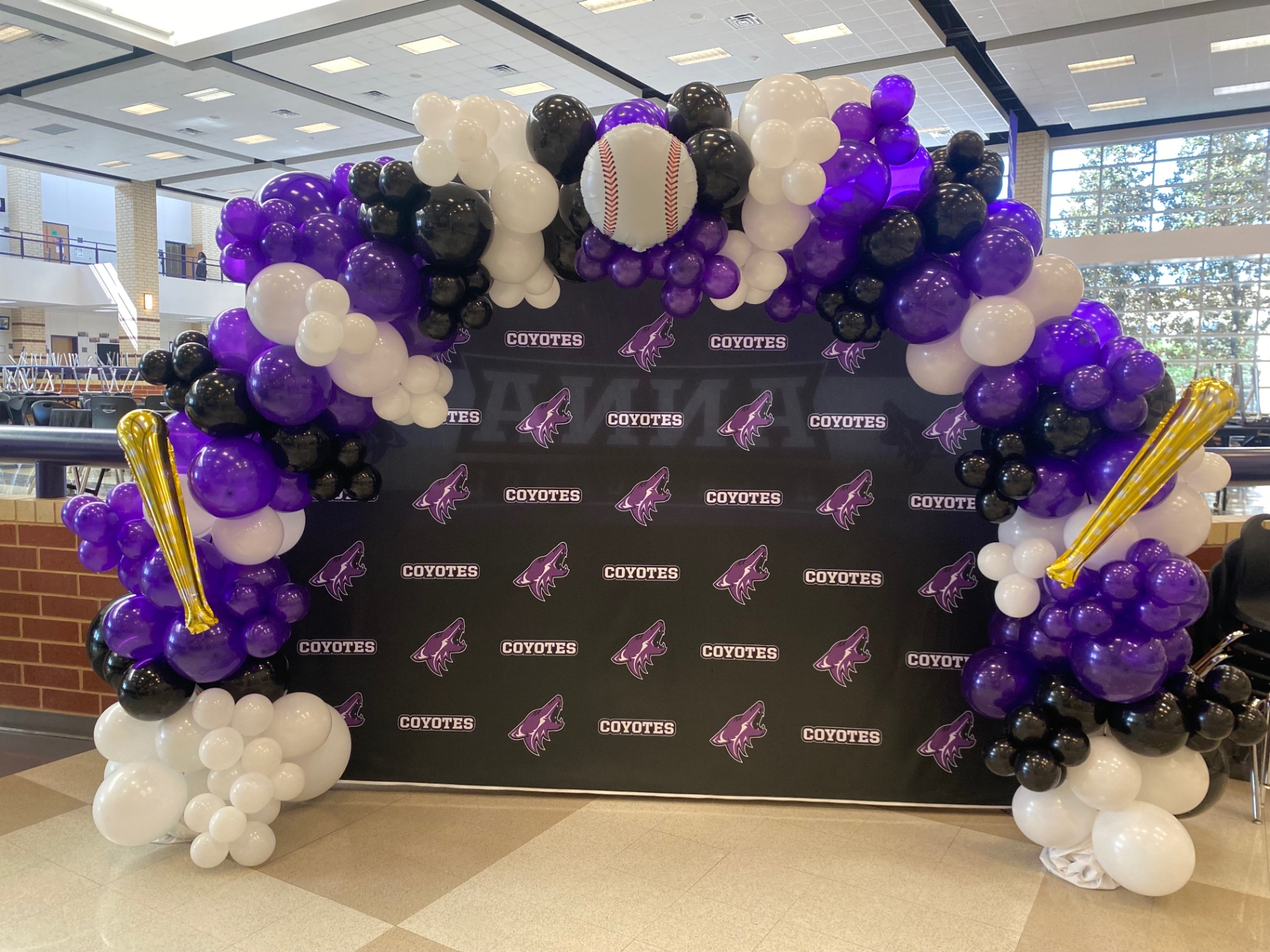Purple, black, and white baseball-themed balloon arch