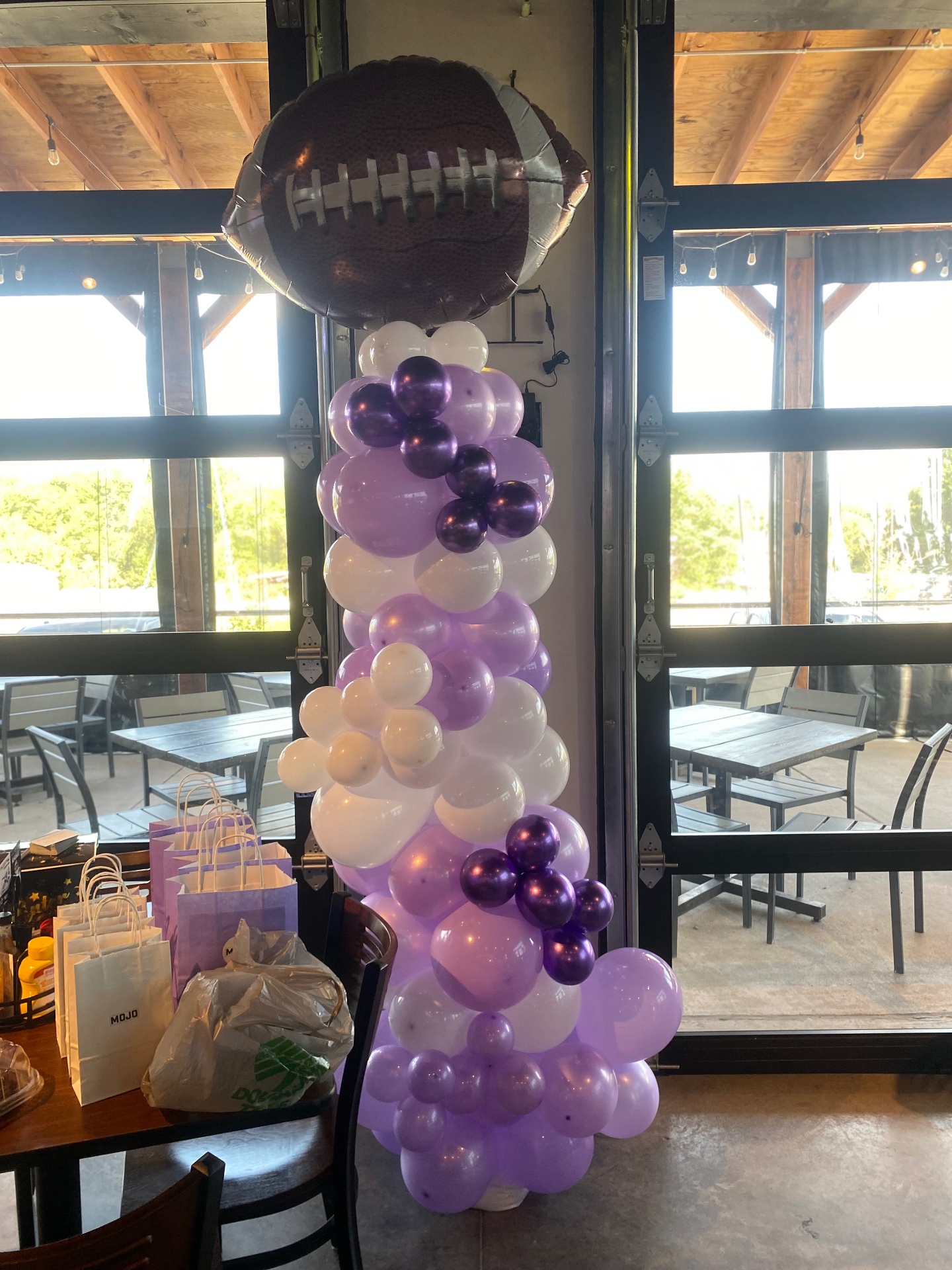 Football-themed purple and white balloon column at the Anna Coyotes 2026 watch party at 2nd Avenue Grill
