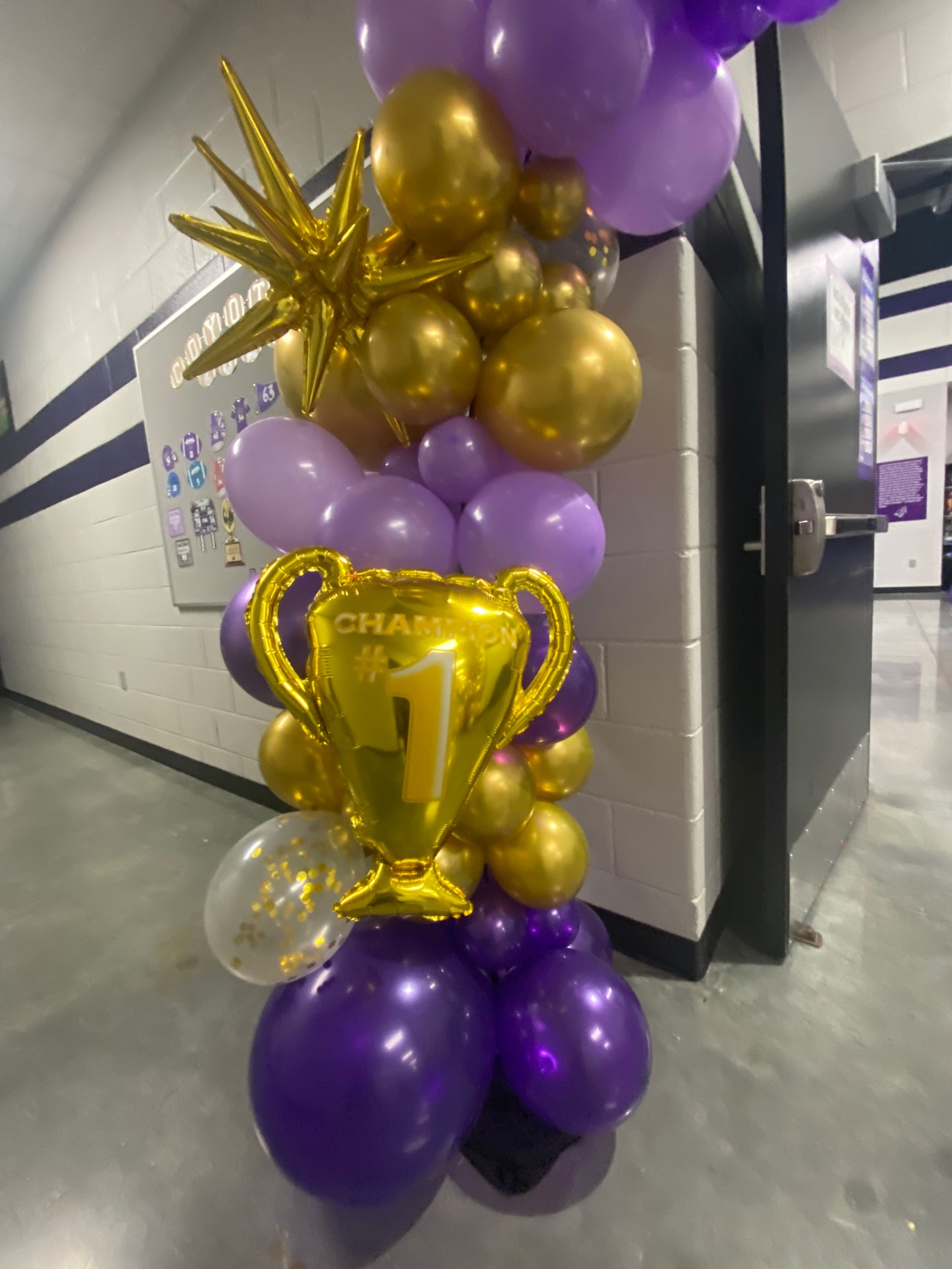 Purple, lavender, and gold champion trophy balloon column with gold starburst topper