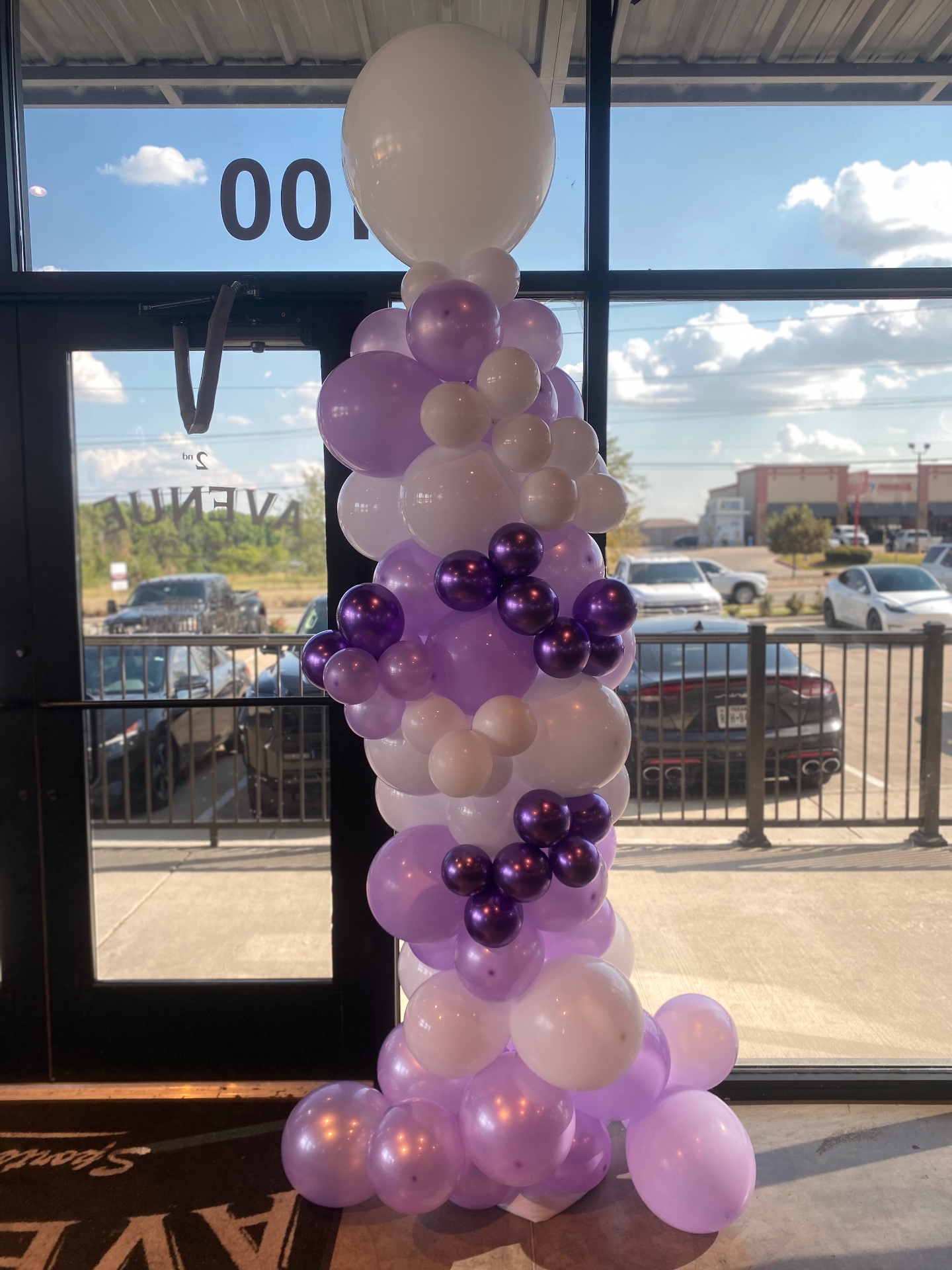 Purple and white organic balloon column at the Anna Coyotes 2026 season opener watch party at 2nd Avenue Grill