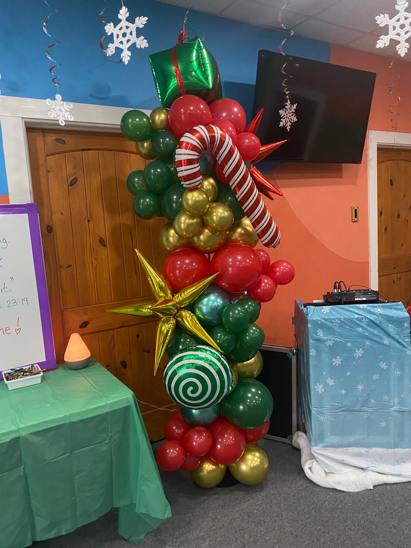 Tall Christmas balloon column with candy cane, gift, star, and swirl accents